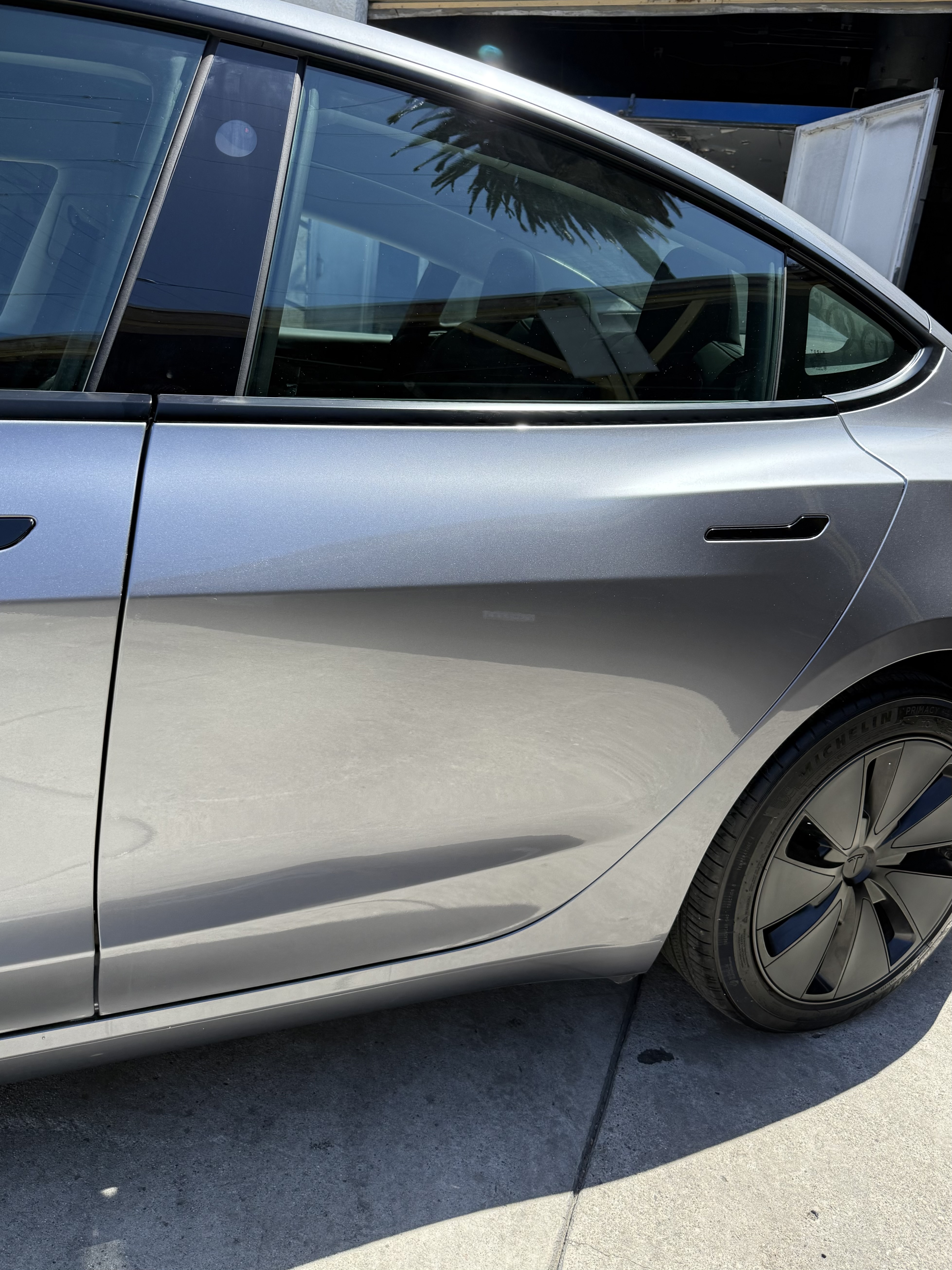 After: silver Tesla Model 3 rear door dent and crease repair